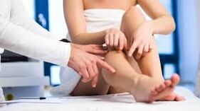 Der Arzt untersucht das Bein des Patienten